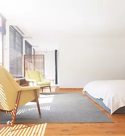 a modern bedroom with yellow chairs